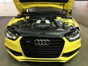 yellow audi in a garage with its hood open